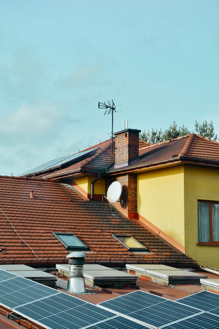 About Yellow building with solar panels and antennas on rooftop in Poland. Eco-friendly technology.